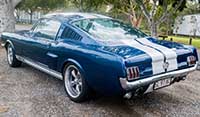 Rear left quarter view Blue Shelby 1965 Mustang Fastback with Wimbledon white lemans stripes