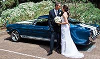 Wedding couple posing for photo’s along side their East Coast hired Mustang Fastback
