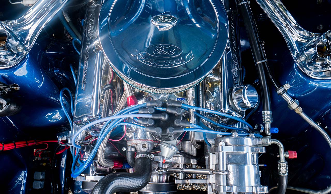 Blue Shelby 1965 Mustang Fastback V8 engine bay close up view with chrome detail