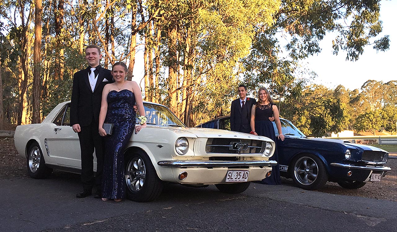 Side view Blue Shelby 1965 Mustang Fastback with young attractive girl in lemon yellow formal dress